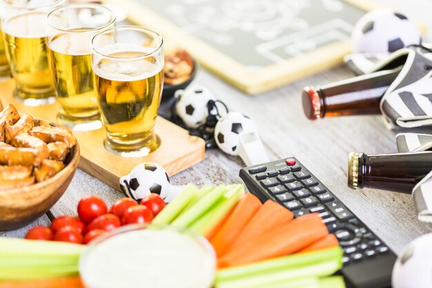 Cerveza de barril y bocadillos salados en la mesa para la fiesta de fútbol.