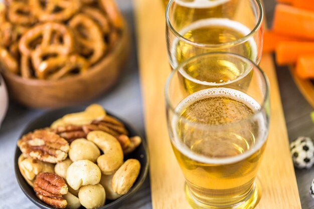 Cerveza de barril y bocadillos salados en la mesa para la fiesta de fútbol.