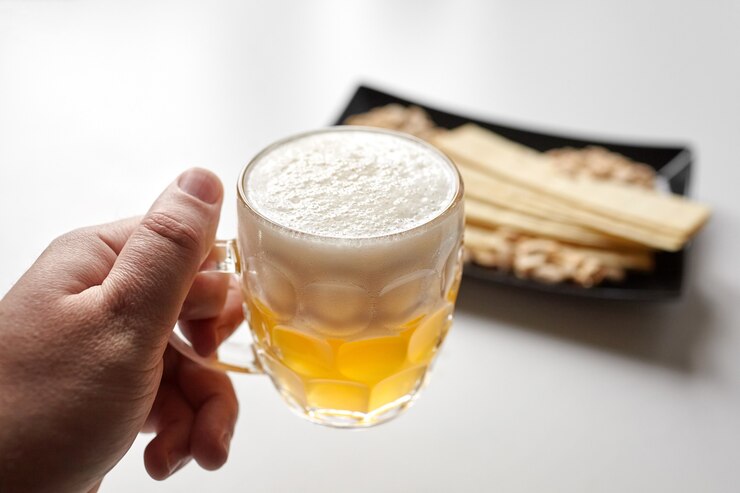 Cerveza blanca sin filtrar, papas fritas largas, maní pelado tostado salado en placa negra