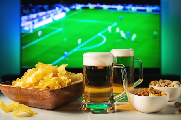 Cerveza y bocadillos en el fondo de la televisión del partido de fútbol.