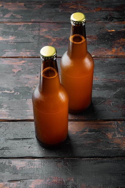 Cerveza fresca en botellas de vidrio, en la vieja mesa de madera oscura.