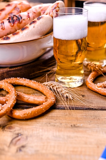 Cerveza fresca con espuma en madera. Oktoberfest Pretzels alemanes.