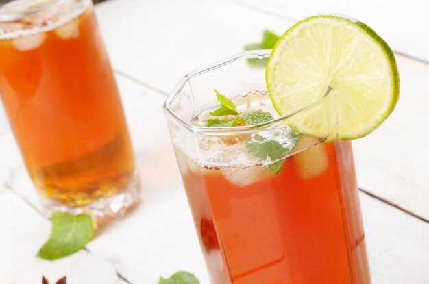 Cerveza de frutas de lima y menta con hielo sobre mesa blanca