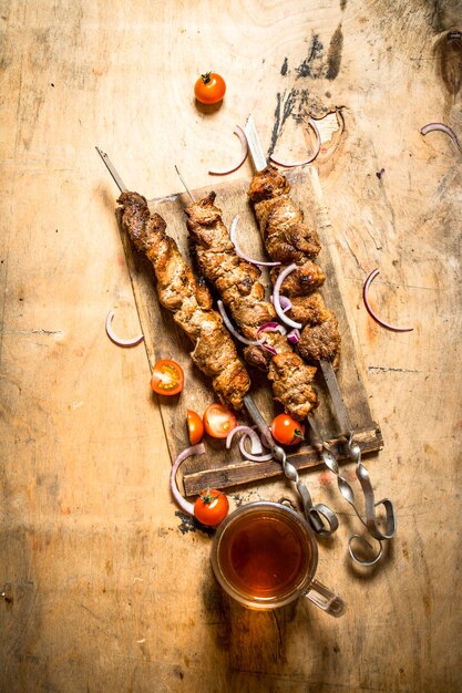 Cerveza con kebab de cerdo y tomates.