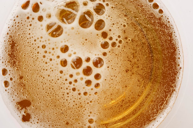 Cerveza ligera en un vaso con espuma y burbujas