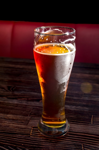 Cerveza light en un vaso sobre una mesa de madera