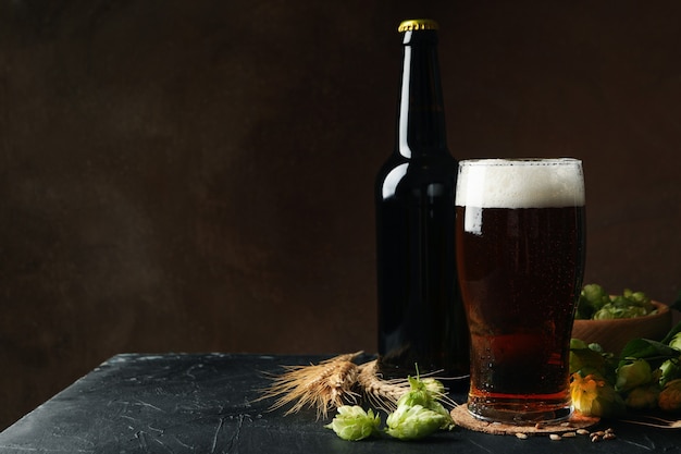 Foto cerveza, lúpulo y trigo contra la pared marrón