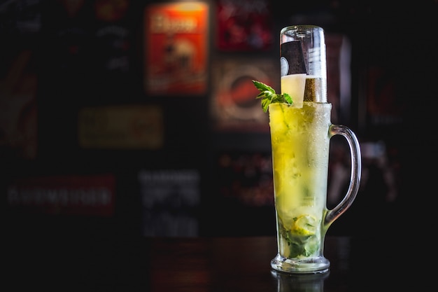 Cerveza mojito en un bar de ambiente oscuro.