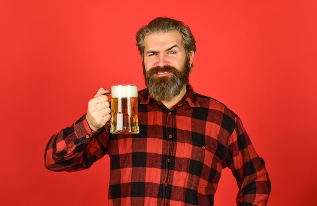 Cerveza Oktoberfest Barman con estilo o barman en la recreación del bar El hombre sostiene un vaso de cerveza hipster en el mostrador del bar divirtiéndose viendo fútbol