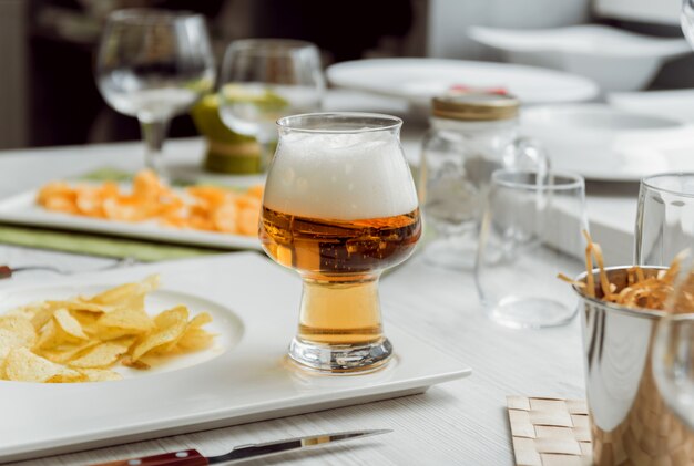 Cerveza y papas fritas en una gran mesa blanca