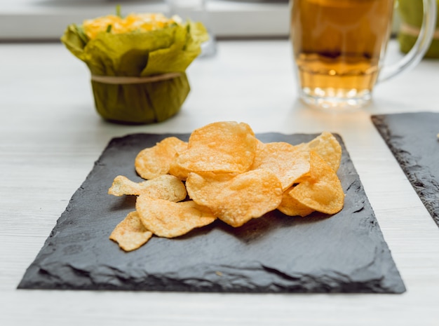 Cerveza y papas fritas en una gran mesa blanca