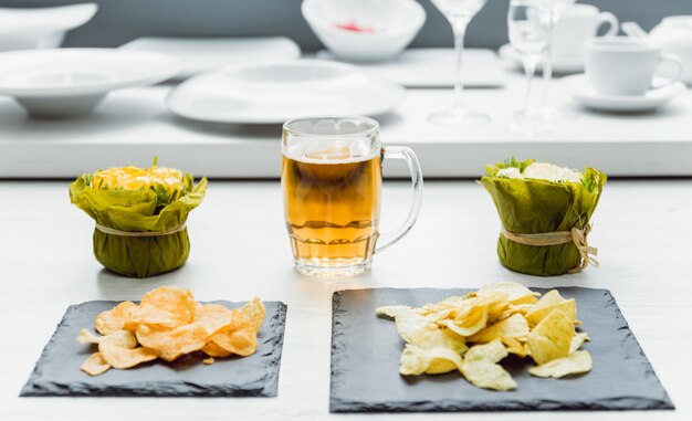 Cerveza y papas fritas en una gran mesa blanca