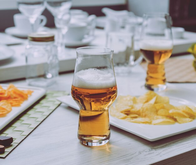 Cerveza y papas fritas en la gran mesa blanca