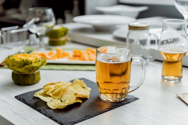 Cerveza y papas fritas en la gran mesa blanca