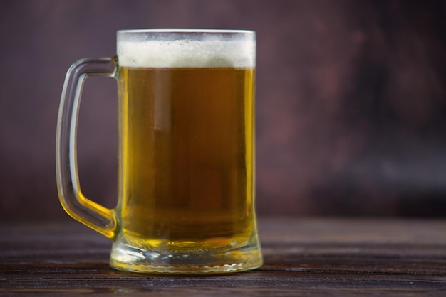 Foto cerveza y papas fritas un vaso de cerveza ligera con una gran cabeza de espuma papas fritas en un recipiente de vidrio