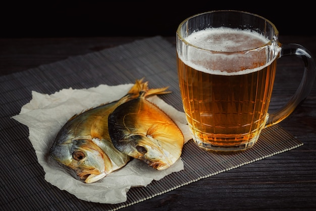 Cerveza y pescado seco en la mesa de madera oscura. Aperitivo de cerveza y cerveza.