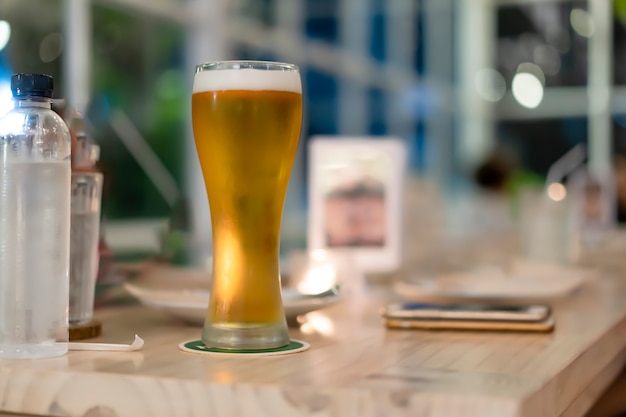 Cerveza en un vaso alto que se coloca sobre la mesa.