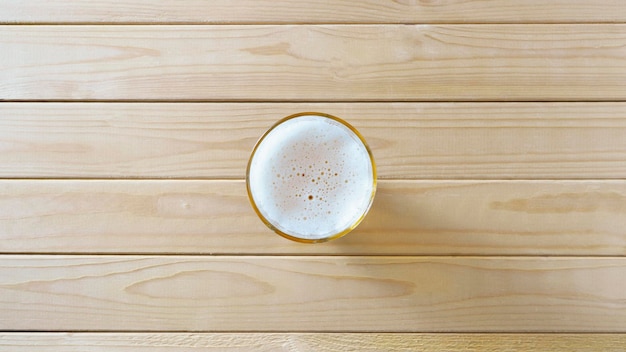 Cerveza en vaso sobre madera clara