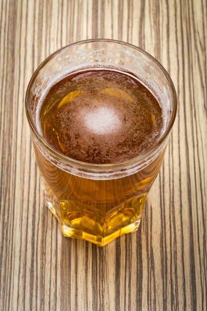 Cerveza en el vaso y tapas de mesa de madera.