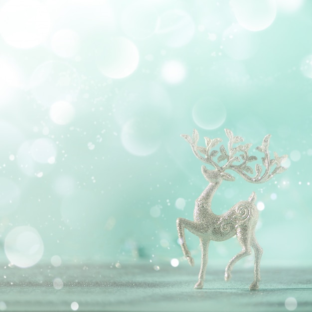 Cervos de prata do Natal do glitter no fundo azul com bokeh das luzes, espaço da cópia.
