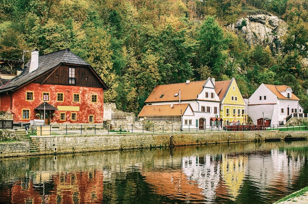 Cesky Krumlov - uma famosa cidade histórica tcheca bonita, vista para o rio da cidade e uma bela rua de outono com edifícios coloridos e árvores de outono. Fundo europeu de viagem