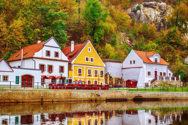 Cesky Krumlov - uma famosa cidade histórica tcheca bonita, vista para o rio da cidade e uma bela rua de outono com edifícios coloridos e árvores de outono. Fundo europeu de viagem