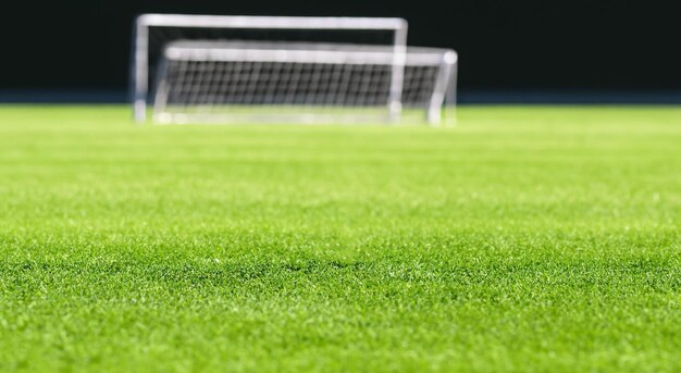 Césped verde de campo de fútbol con un arco de fondo con maya