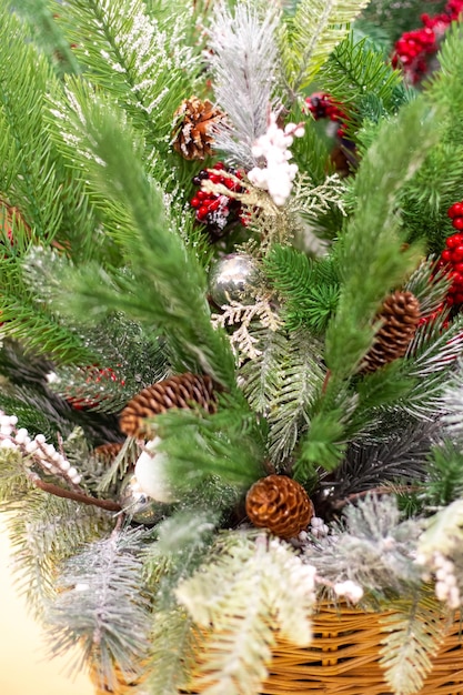 Cesta con adornos navideños. Ramitas de árboles de Navidad verdes con conos y juguetes.