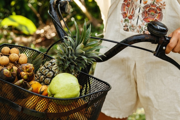 Cesta en la bicicleta llena de diferentes frutas exóticas