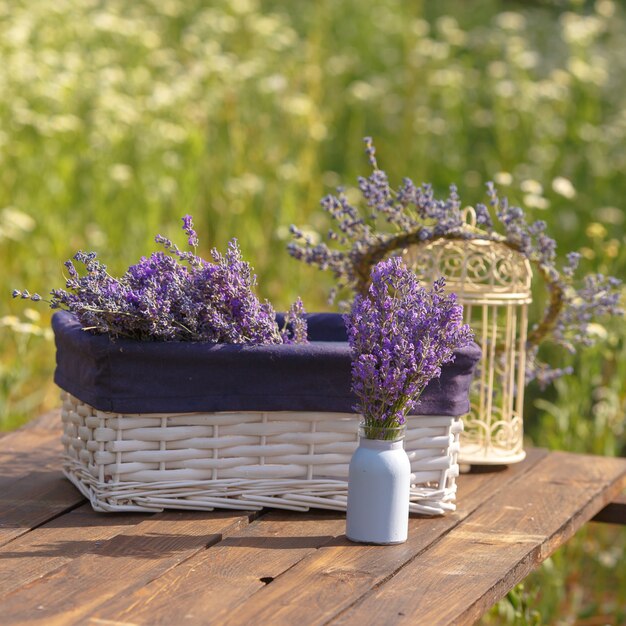 Foto cesta branca com lavanda em uma mesa de madeira