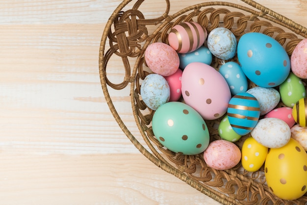 Cesta con coloridos huevos de Pascua en madera