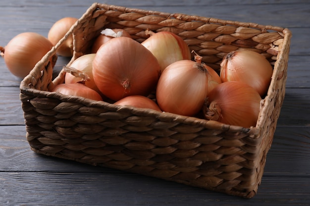 Cesta com cebola fresca em madeira