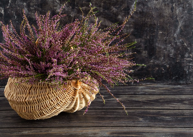 Cesta com flores sobre fundo preto urze lilás