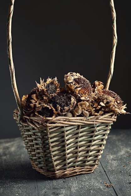 Cesta com girassóis secos isolados em uma mesa de madeira