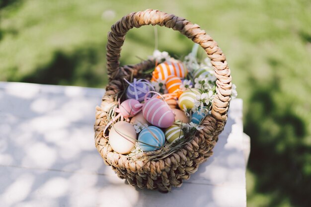 Cesta com ovos decorativos de páscoa no jardim cartão de feliz páscoa