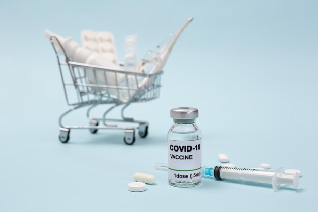 Cesta de la compra con medicamentos y vacunas de covid19 sobre un fondo azul Coronavirus