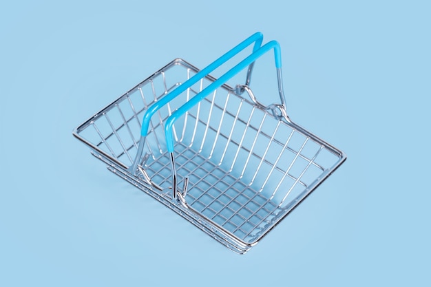 Foto cesta de la compra del supermercado sobre fondo azul claro. cesta de alambre de metal vacía. viernes negro, venta, concepto de compras. estilo de vida sostenible.