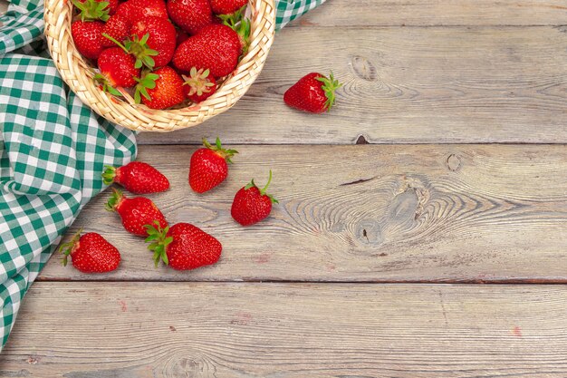 Cesta de cosecha de fresas en mesa de madera