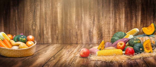 Cesta con cosecha de verduras y frutas en el fondo de madera para el día de acción de gracias