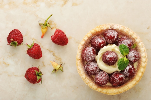 Cesta de bolo com framboesas frescas e sobremesa de creme de frutas