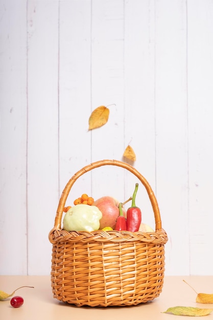 Cesta de colheita de outono com abobrinha de maçã e pimentão em um fundo de madeira