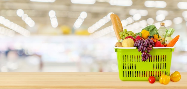 Cesta de compras na mesa de madeira com fundo de supermercado