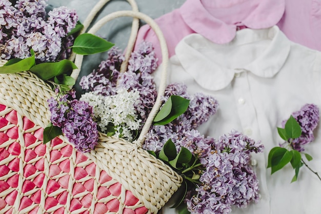 Foto cesta de flores lilás rosa pastel e vestido de verão branco em mulheres de fundo cinza texturizado