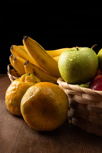 Cesta de frutas tropicais em detalhes em superfície de madeira