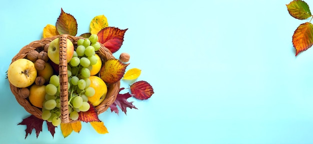 Cesta de fundo de ação de graças com frutas frescas de outono e folhas de outono