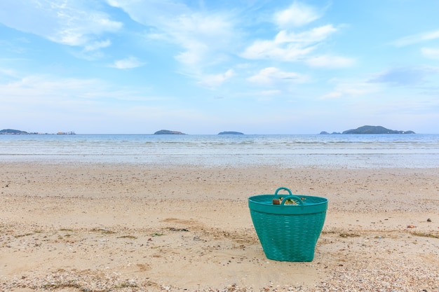 Cesta de lixo verde na praia