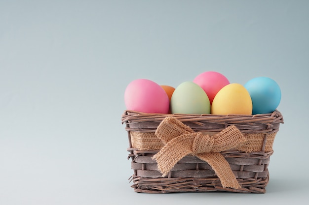 Cesta de madeira com ovos coloridos bonitos Páscoa feliz, boa placa para um cartão.