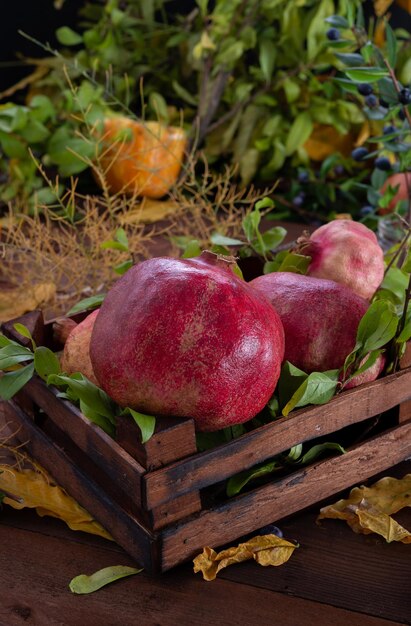 Cesta de madeira com romãs e vários adereços