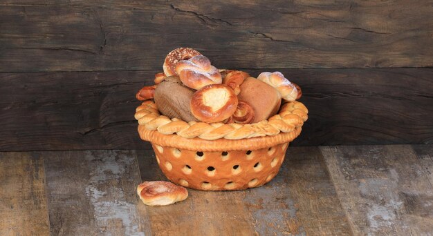 cesta de pães com pãezinhos doces em fundo de madeira