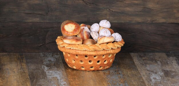 cesta de pães com pãezinhos doces em fundo de madeira